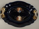 a black plate with gold trim and a picture of a man and a woman on it
