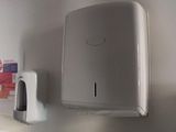 un distributeur de papier essuie-tout fixé au mur au-dessus d'un lavabo