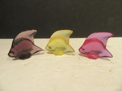 trois figurines de poissons de couleurs différentes posées sur une table