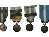 three medals are displayed on a white background with a blue and white stripe