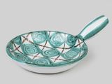 turquoise and white bowl with a spoon sitting on top of it