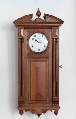a wooden clock hanging on the wall in a room