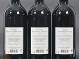 three bottles of red wine sitting next to each other on a table
