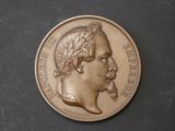 l'image d'une médaille d'or sur laquelle figure le visage d'un homme