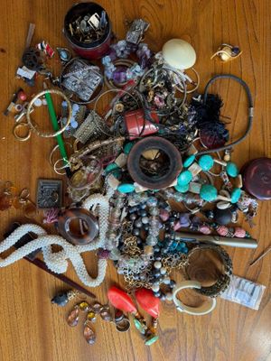 a pile of assorted jewelry on a wooden table