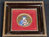 an old picture of a woman holding a baby in a wooden frame