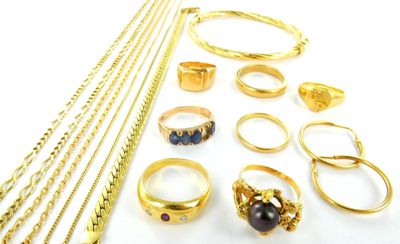 a lot of gold rings and necklaces on a white surface