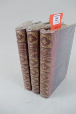 trois livres sont empilés sur une surface blanche