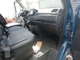 the interior of a blue truck with the door open and the passenger seat down