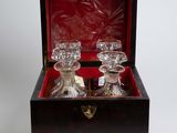two glass decanters in a wooden box on a white surface