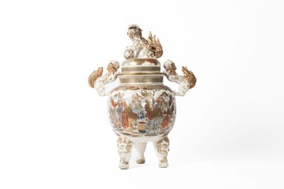 un vase blanc surmonté d'un oiseau