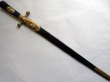 une épée noire et dorée sur un fond blanc