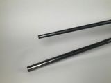 two black chopsticks sitting next to each other on a white surface