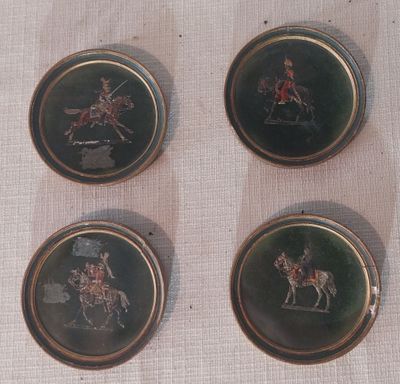 quatre boutons en métal sur lesquels figure l'image d'un homme à cheval
