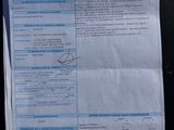 a receipt on the back of a car that is parked in the street