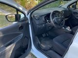 the interior of a car with the door open and the driver ' s seat down