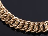 a close up of a gold chain necklace on a black surface