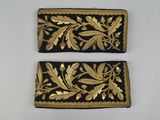 two black and gold embroidered purses on a white surface