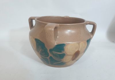 un vase marron orné de motifs bleus et jaunes