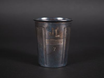 une vieille tasse en métal posée sur une table noire