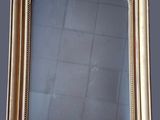 an antique gold framed mirror on a grey background