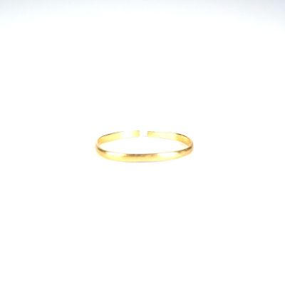 gros plan d'une bague en or sur une surface blanche