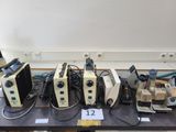 tout un tas de microscopes de différents types posés sur une table