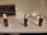 three bottles of perfume sitting on a counter with a chalkboard