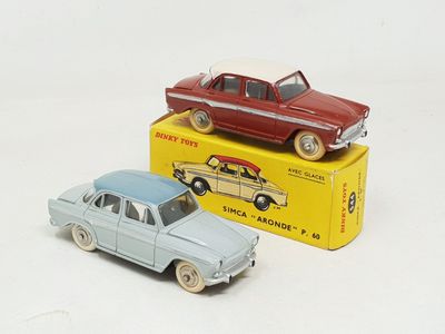 two toy cars sitting next to each other on a white surface