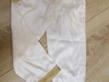 a white and gold outfit sitting on a wooden floor