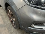 a close up of the front of a car with a dent in it