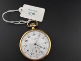 un gros plan d'une montre de poche à laquelle est accrochée une étiquette