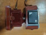 a brown leather case with an old camera on it