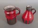 two red vases sitting next to each other on a table