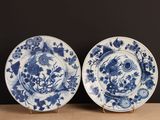 two blue and white plates with flowers on them on a table