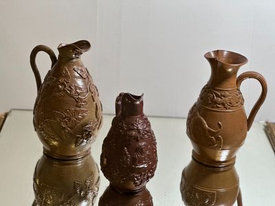 three vases sitting on top of a glass table