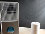 a small air conditioner sitting on the floor next to a trash can