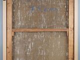an old wooden frame with writing on it and a window in the background