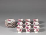 several cups and saucers with pink flowers on them on a table