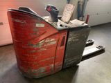 un chariot élévateur sur lequel est posée une caisse, dans un garage