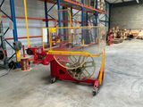 un chariot rouge avec une roue jaune à l'intérieur d'un entrepôt