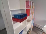 a white book shelf with a bunch of books on top of it