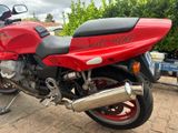 a red motorcycle that is parked on the side of the road