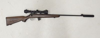 Le fusil est posé par terre, près du mur.