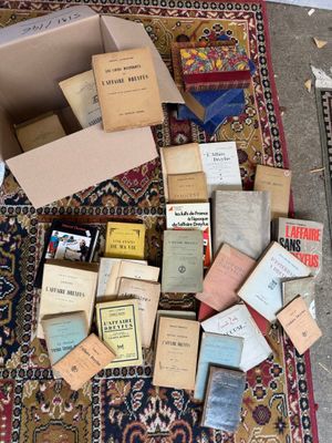 a pile of old books on the floor next to a box