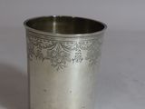 une tasse en argent antique avec un motif floral sur le bord