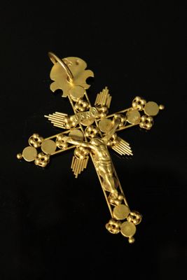 a close up of a gold cross on a black background
