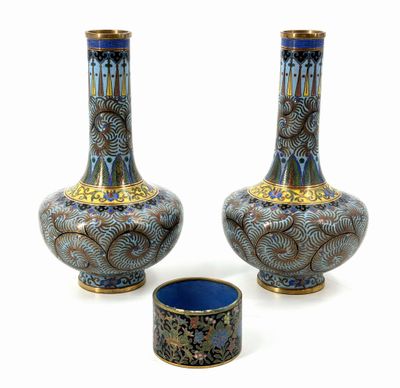pair of blue and gold vases sitting next to each other on a white surface