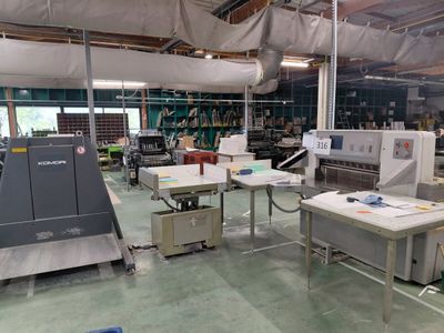 une grande salle où se trouvent de nombreuses machines et tables