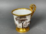 a close up of a cup on a table with a tree in the background